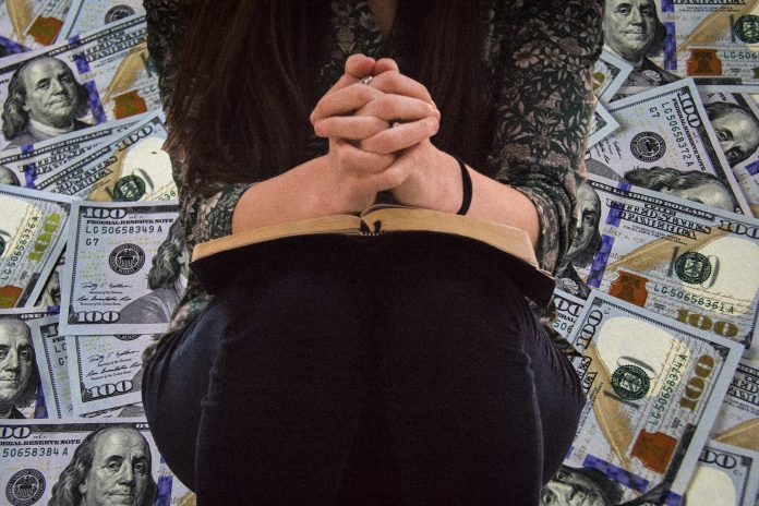 Žena u molitvi s novcem iza nje