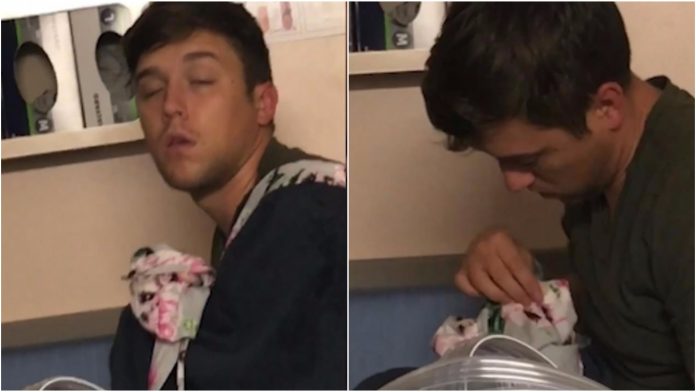 Pospani tata je uvjeren da drži bebu Pospani tata je uvjeren da drži bebu