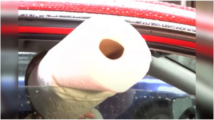 Gurnula rolu papira kroz prozor automobila