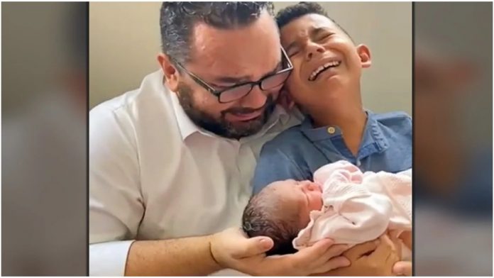 Otac i sin plaču dok drže bebu