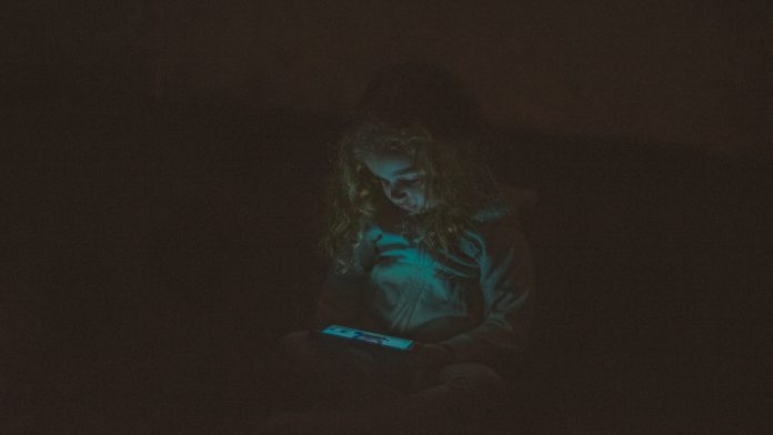 Djevojčica drži mobitel u rukama